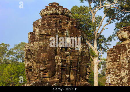 Tower con tre dei 216 scolpiti volti sorridenti a 12thC tempio Bayon in Angkor Thom città murata; Angkor, Siem Reap, Cambogia. Foto Stock