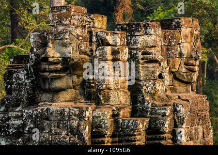 Tower con 2 dei 216 sorridenti facce di pietra arenaria a 12thC tempio Bayon in Angkor Thom città murata; Angkor, Siem Reap, Cambogia. Foto Stock