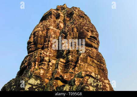 Tower con 2 dei 216 sorridenti facce di pietra arenaria a 12thC tempio Bayon in Angkor Thom città murata; Angkor, Siem Reap, Cambogia. Foto Stock