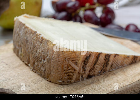 Pezzo di formaggio francese Tomme de brebis realizzato dal latte di pecora è servito come dessert con fichi freschi e pere close up Foto Stock