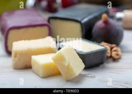 Mini nero e rosso scuro cerata formaggi cheddar realizzato da ovest paese latte e secolare e metodi in Inghilterra da vicino Foto Stock