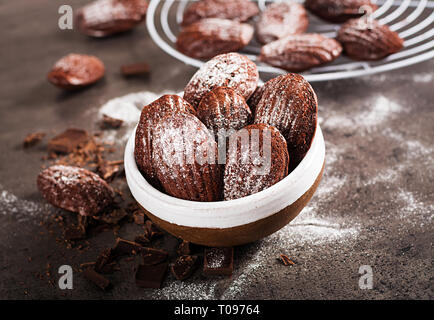 Biscotti al cioccolato. Cioccolato artigianale Madeleines sulla tabella di scuro. Cucina francese. Foto Stock