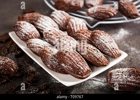 Biscotti al cioccolato. Cioccolato artigianale Madeleines sulla tabella di scuro. Cucina francese. Foto Stock