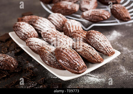 Biscotti al cioccolato. Cioccolato artigianale Madeleines sulla tabella di scuro. Cucina francese. Foto Stock