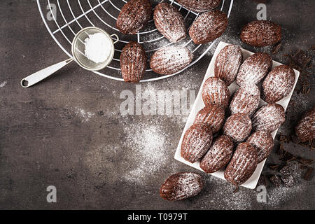 Biscotti al cioccolato. Cioccolato artigianale Madeleines sulla tabella di scuro. Cucina francese. Vista superiore Foto Stock