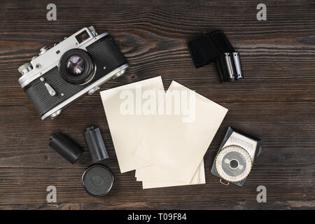 Angolo di alta vista di una fotocamera vintage, pellicola, carta fotografica e misuratore di luce Foto Stock