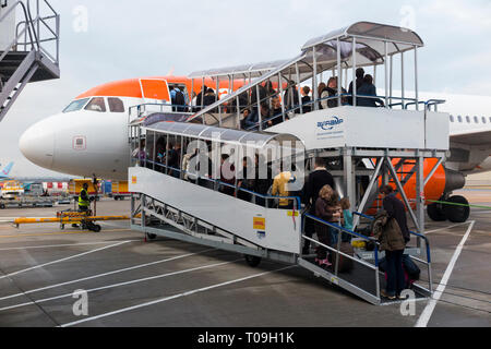 Un Easyjet Airbus A320 o A319) d'imbarco del volo i passeggeri con attrezzature di supporto a terra - ponte mobile di ramp - all'Aeroporto Gatwick di Londra, Regno Unito. (104) Foto Stock