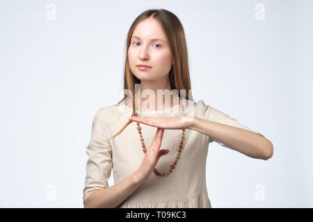 Giovane donna graziosa stanco ed annoiato, facendo un gesto di timeout Foto Stock