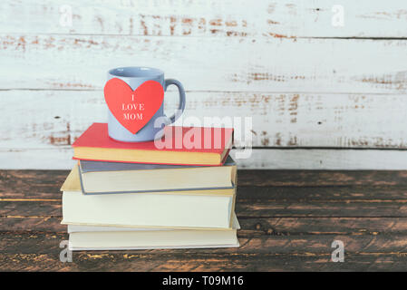 Io amo mamma, libri accanto a una tazza di caffè su di un tavolo di legno Foto Stock