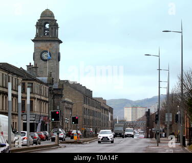 Glasgow, Scotland, Regno Unito 18 marzo, 2019. vista di Clydebank main street con il traffico di fronte al municipio, città del saldatore iconica cantieristica locale memorial statua dato il cono di testa di arte moderna il trattamento che ha reso il Duca di Wellington statua simbolo della città. È diventato uno standard in tutta la Scozia che locale statue venerate ricevono il trattamento anarchica sulla strada per accettazione come un popolare forma d'arte. Credito: Gerard Ferry/Alamy Live News Foto Stock