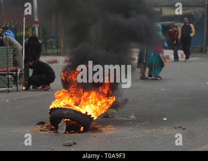 Srinagar Kashmir. 19 mar 2019. Manifestanti arrabbiati bruciare pneumatici sulla strada fuori dal Grande moschea durante una manifestazione di protesta contro la Rizwan Asad, morto in carcere. Rizwan Asad, un residente di Awantipore Pulwama, a sud di Srinagar. Un insegnante che è stato arrestato dalla polizia indiana e la nazionale agenzia investigativa (NIA) in connessione con un terrore. L'incidente ha scatenato le proteste in molte parti dello stato. Credito: sofi suhail/Alamy Live News Foto Stock