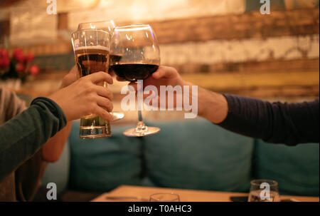Amici in un ristorante La tostatura la birra e il vino. Tre amici nel ristorante celebrando. Sera andare fuori Foto Stock