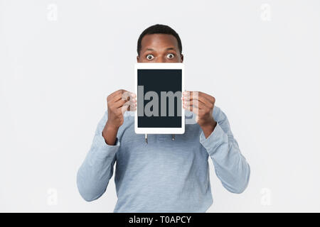 Giovane africano con la compressa che mostra lo schermo del tablet PC moderni. Foto Stock
