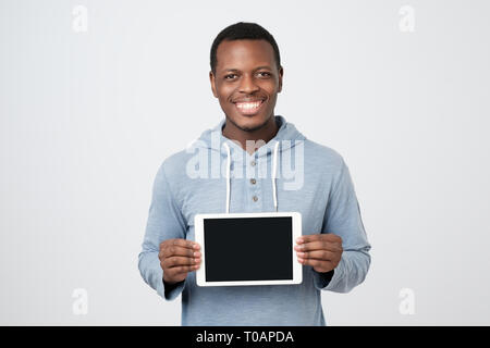 Giovane africano con la compressa che mostra lo schermo del tablet PC moderni. Foto Stock