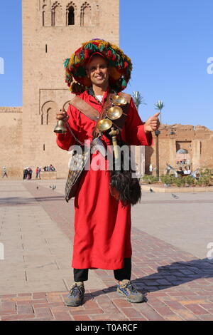 Gerrab (acqua venditore) al di fuori della moschea di Koutoubia (lato est), Medina, Marrakech, regione Marrakesh-Safi, Marocco, Africa del nord Foto Stock