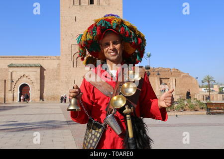 Gerrab (acqua venditore) al di fuori della moschea di Koutoubia (lato est), Medina, Marrakech, regione Marrakesh-Safi, Marocco, Africa del nord Foto Stock