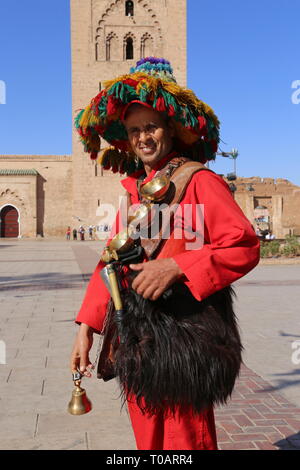 Gerrab (acqua venditore) al di fuori della moschea di Koutoubia (lato est), Medina, Marrakech, regione Marrakesh-Safi, Marocco, Africa del nord Foto Stock