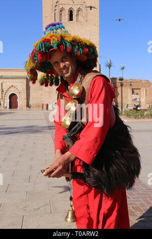 Gerrab (acqua venditore) al di fuori della moschea di Koutoubia (lato est), Medina, Marrakech, regione Marrakesh-Safi, Marocco, Africa del nord Foto Stock