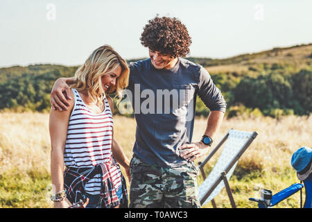 Felice coppia giovane gode di una giornata di sole in natura, abbracciando l'altra. Foto Stock