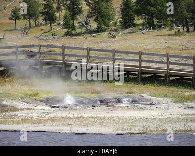 Primo piano di una sorgente termale e di una passerella in legno di sorgenti termali calde al Parco Nazionale di Yellowstone. Foto Stock