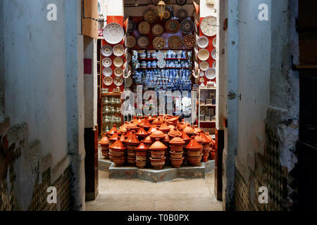 Negozio con pile di tajine di pentole e altri oggetti per il servizio da tavola tradizionale nel cuore della medina di Fez, in Marocco. Foto Stock