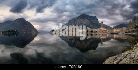Panorama della città di Lecco riflesse sul lago in una incredibile giorno nuvoloso, Lombardia, Italia Foto Stock