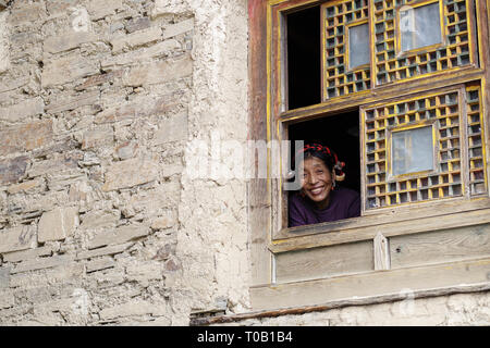 Donna sorridente si affaccia dalla tradizionale finestra tibetano, Tibet orientale, prosciutto, sichuan Foto Stock