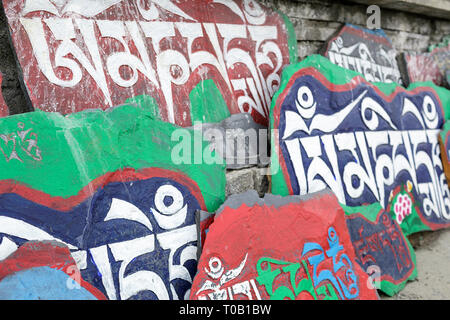 Mani lungo muro di pietra, Tagong, Sichuan, in Cina Foto Stock