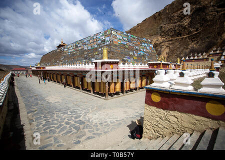 Pellegrini a mani lungo muro di pietra a Ser Gergyo (Ani Gompa) convento, Tagong, Sichuan, in Cina Foto Stock