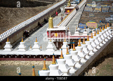 Pellegrini a mani lungo muro di pietra a Ser Gergyo (Ani Gompa) convento, Tagong, Sichuan, in Cina Foto Stock