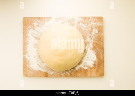 Passo dopo passo la ricetta per preparare un gustoso challah, Lista ingredienti 500 grammi di lievito di frumento su un grande vaso di porcela, vista dall'alto su uno sfondo giallo, Foto Stock