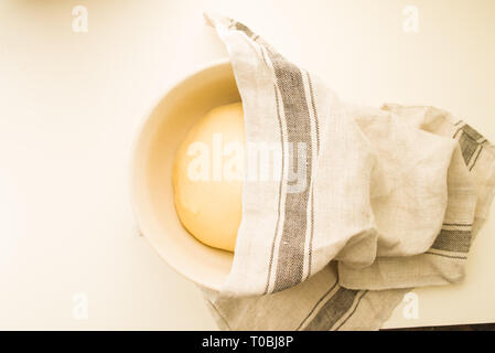 Passo dopo passo la ricetta per preparare un gustoso challah, Lista ingredienti 500 grammi di lievito di frumento su un grande vaso di porcela, vista dall'alto su uno sfondo giallo, Foto Stock