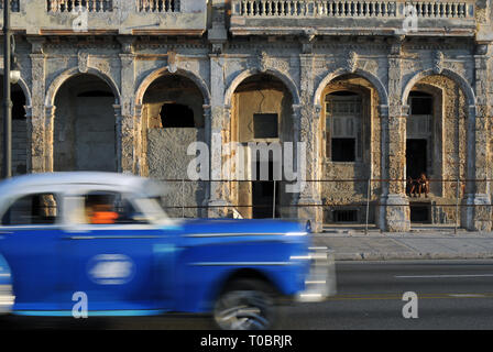 Un auto classica trascina lungo il Malecón a l'Avana, Cuba. Molti degli edifici che fiancheggiano il popolare lungomare esplanade sono in necessità di riparazione. Foto Stock