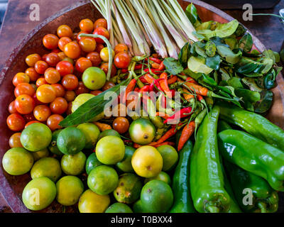 Ciotola di colorati ingredienti freschi con pomodori alla citronella chilie limes e peperoni a scuola di cucina, Luang Prabang, Laos Foto Stock