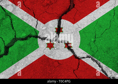 Burundi bandiera sulla terra incrinato. Bandiera nazionale del Burundi. Un terremoto o un concetto di siccità Foto Stock