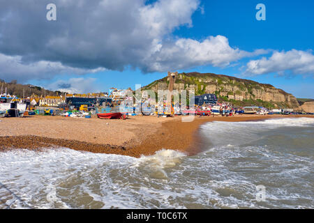 Hastings, East Sussex, Regno Unito. Il 10 marzo 2019. Hastings barche da pesca tirato su in alto sulla spiaggia di Stade al di fuori della portata delle onde pilotato da gale force venti Foto Stock