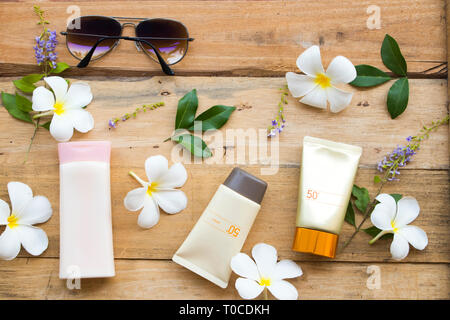 Prodotti cosmetici naturali protezione solare SPF50 per la faccia di pelle salute bellezza cura di proteggere e crema per il corpo della donna di stile di vita relax estate con fiori di frangipani Foto Stock