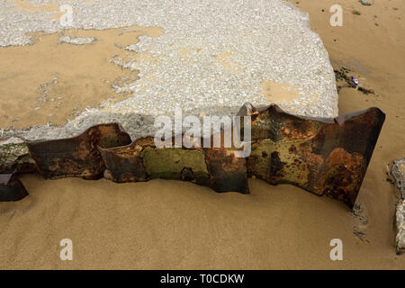 Muro di cemento danneggiato e lamiera di acciaio che si allatta sulla spiaggia sabbiosa a bassa marea ad ancorsholme a blackpool, costa fylde nel lancashire uk Foto Stock