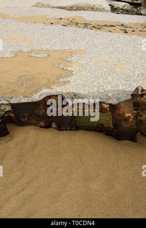 Muro di cemento danneggiato e lamiera di acciaio che si allatta sulla spiaggia sabbiosa a bassa marea ad ancorsholme a blackpool, costa fylde nel lancashire uk Foto Stock