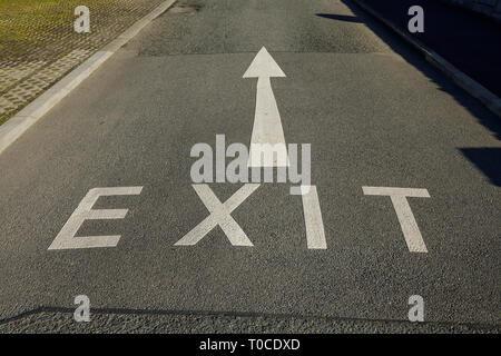 Un segnale di uscita e la freccia dipinta su una strada nel Regno Unito Foto Stock