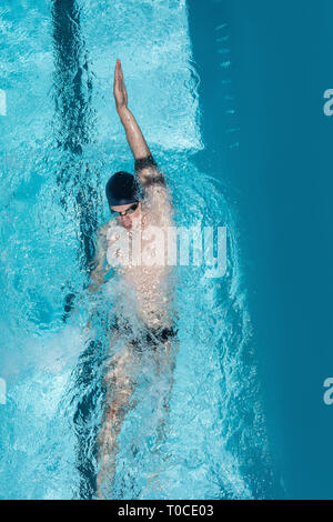 Giovani nuotatore nuoto dorso in piscina Foto Stock