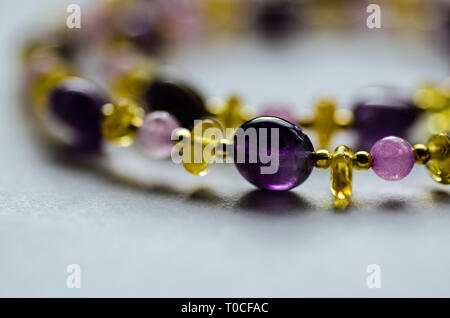 Collana fatta a mano da ametista e quarzo e perle di ambra intervallati con placcato oro perle. Foto Stock