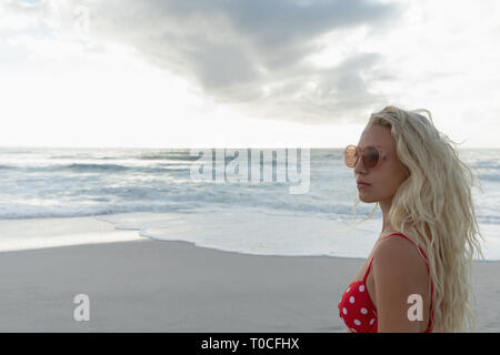 Bella bionda Caucasian woman standing in spiaggia in una giornata di sole Foto Stock
