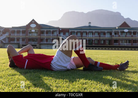 Maschio ferito giocatore di rugby giacente a terra Foto Stock