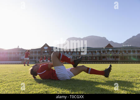 Maschio ferito giocatore di rugby giacente a terra Foto Stock