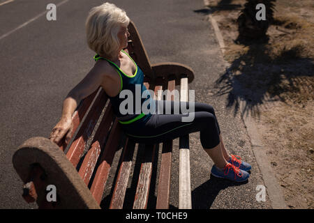 Attiva donna senior relax su una panchina vicino alla spiaggia Foto Stock