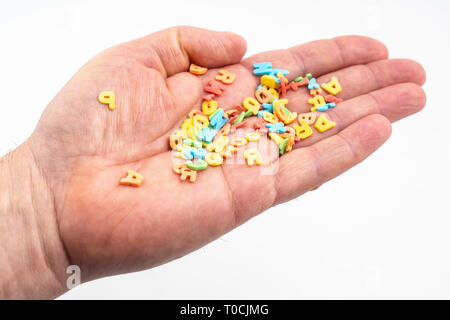 La colorata lettere sparsi nel palmo di una mano Foto Stock