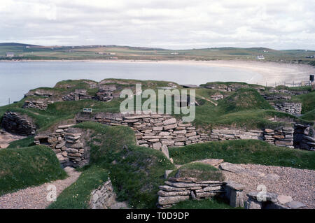 Anni sessanta, Highlands scozzesi, costa ovest del continente, isole Orcadi, preistoria Skara Brae insediamento di pietra con la baia di Skaill in background. Foto Stock