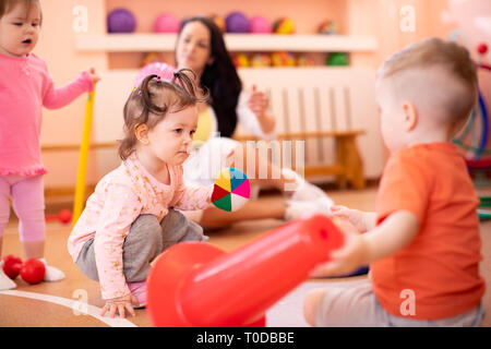 Gruppo di bambini con trainer in asilo nido palestra Foto Stock