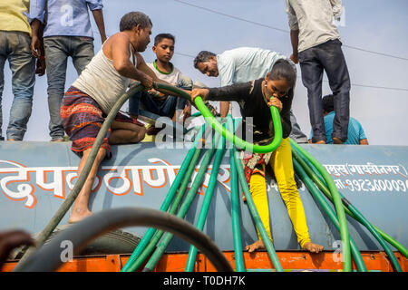 Persone acqua di riempimento in fusti di plastica da acqua petroliera Bhiwandi, Maharashtra, India Foto Stock